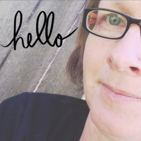 image: part of my face, a fair skinned person with blue eyes wearing black rimmed glasses, and my shoulder in a black shirt, in front of a grey wooden fence. The word "hello" is superimposed in the top left corner of the image over the fence